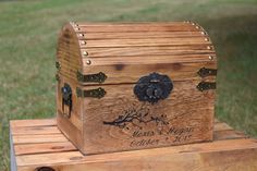 a wooden chest sitting on top of a box in the middle of some grass with an emoticive smiley face above it