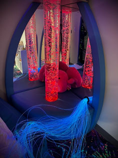 Photos of sensory rooms with special coloured lighting, bubble tubes, fibre optic strand lighting and special furniture for relaxing on. 70s Apartment, Sensory Room Equipment, Dressing Tool, Indie Bedroom, Bathroom Tool, Sensory Rooms, Neon Birthday, Power Chair, Sensory Room