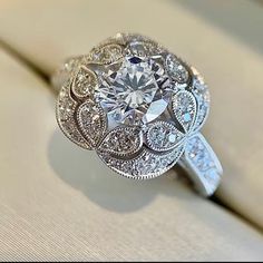 a fancy diamond ring sitting on top of a table