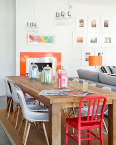 a dining room table with chairs and a couch in front of the fire place on the wall