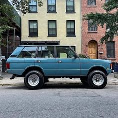 a blue suv parked in front of some buildings