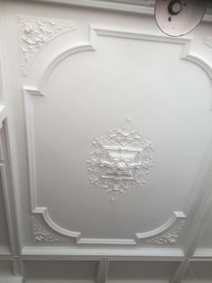 the ceiling is painted white and has ornate designs on it