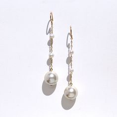 Striking, sophisticated modern pearl cascading earrings. A duo of delicate tiny  3mm freshwater pearls set off a large vintage faux pearl accent drop. The pearls, sitting along a delicate whisper of 14k gold filled chain, create a super chic minimal look that will offset a harder masculine outfit, and work equally well with feminine, bridal looks. The French earwires are made of 14k gold filled metal. 14k gold filled metal does not flake off and contains significantly more gold than regular 'gol 14k Gold Filled Pearl White Dangle Pearl Earrings, Delicate Pearl Chain Earrings, 14k Gold-filled Pearl White Dangle Pearl Earrings, Dangle Pearl Earrings With Pearl Chain, Delicate Pearl Chain Dangle Earrings, Elegant Pearl Linear Earrings With Ear Wire, Pearl Linear Long Drop Earrings, Long Drop Pearl Linear Earrings, White Minimalist Pearl Drop Earrings