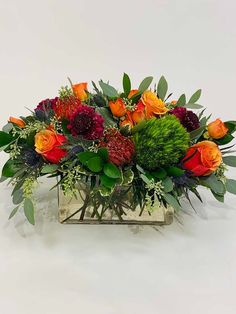 a vase filled with lots of different colored flowers