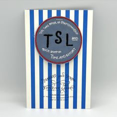 a blue and white striped card with a black tsl patch on it