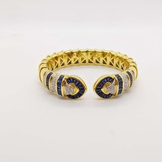 For Sale on 1stDibs - No details were spared in this beautiful 18 karat yellow gold cuff bracelet. Long tapered blue sapphires and pave round brilliant diamonds are set forming Luxury Gold Diamond Bracelet With Sapphire, Yellow Gold Cuff Bracelet, Gold Cuff Bracelet, Gold Bracelet Cuff, Gold Cuffs, Brilliant Diamond, Karate, Round Brilliant, Cuff Bracelet