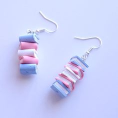 two pairs of earrings made out of rolled up paper on white surface with silver earwires