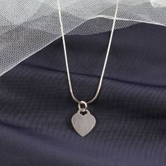 Personalized Heart Pendant Necklace The heart tag measures 17mm x 14mm, and it is made of sterling silver. The pendant is a great size for engraving initials. When you buy the pendant for yourself, you might want to have your own initials engraved but when you are buying it as a gift, you can have the initials of the recipient engraved on the tag instead.  This heart pendant is a nice gift for parents to give to their daughters, and it looks great with most silver chains that she might already have. It is small enough that it will not look too large on a smaller frame, and it will look great with many of the little outfits that she already has. She will love when you engrave her initials on it, and she can show it to her friends proudly. The heart tag pendant is something that she will be Silver Heart Necklace For Mother's Day Memorial, Silver Necklace With Initial Pendant And Heart Charm, Minimalist Heart Pendant Necklace With Charms, Sterling Silver Heart Necklace With Initial Pendant, Sterling Silver Heart Initial Pendant For Mother's Day, Personalized Silver Heart Necklace In Minimalist Style, Personalized Sterling Silver Heart Necklace For Memorial, Personalized Minimalist Silver Heart Necklace, Mother's Day Sterling Silver Heart Necklace With Initial Pendant