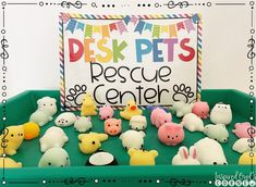 a green tray filled with plastic animals and a sign that says desk pets rescue center