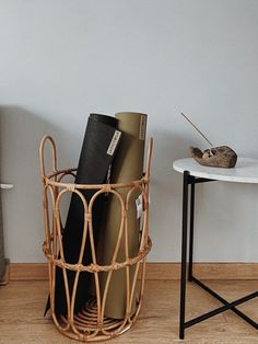 a wicker basket with books in it next to a table