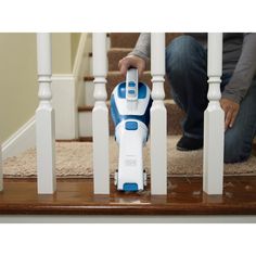 a person kneeling down on the stairs with a vacuum