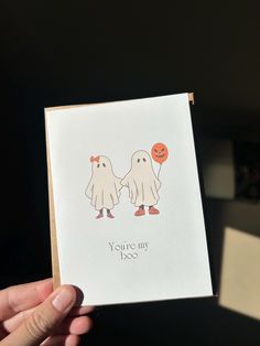 someone holding up a card that says you're my boo and two ghostes