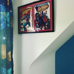 two framed comics are hanging on the wall next to a stair case in a children's room