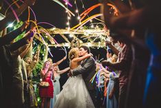 a bride and groom sharing a first dance at their wedding reception with confetti streamers in the air