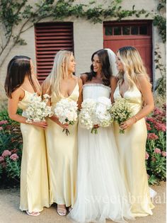 the bridesmaids are all dressed in yellow dresses and holding white bouquets together