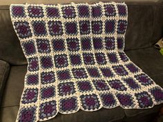 a crocheted blanket is sitting on a couch