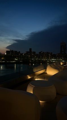 an outdoor seating area at night overlooking the water