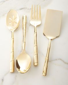 the gold utensils are sitting next to each other on the marble countertop