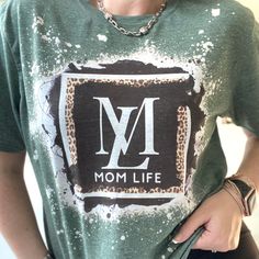 "Feel all the cool Mom vibes in this bleached, heather green shirt. A monogram Mom Life design has been sublimated on this tee for a vintage look. Due to the distressing and bleach detail, no two are alike! Fabric: 65/35 poly/cotton Unisex style. Don't see your size in stock? Contact me for a substitute color with this design. -->What does \"sublimated\" mean? In simple terms, it's a method of printing that transfers a design into the fabric using ink and heat. This results in you being able Trendy Bleached T-shirt With Relaxed Fit, Trendy Cotton T-shirt In Leopard Print, Trendy Bleached T-shirt In Relaxed Fit, Trendy Bleached Relaxed Fit T-shirt, Trendy Tie Dye Tops With Letter Print, Trendy Tie Dye Top With Letter Print, Acid Wash Casual Tops With Custom Print, Acid Wash Casual Top With Custom Print, Casual Acid Wash Top With Custom Print