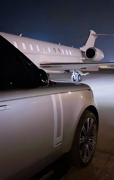 a car parked in front of an airplane at night