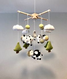 a crocheted mobile hanging from the ceiling with several balls and trees on it