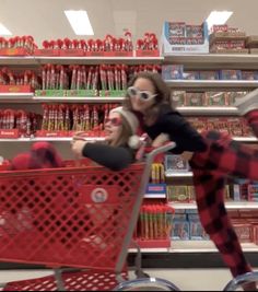 two women in plaid pajamas pushing a shopping cart