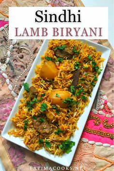 a white plate topped with rice and meat next to a colorful table cloth on top of a