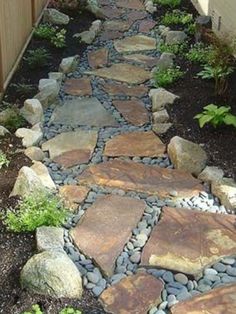 a stone path in the middle of a garden