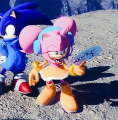 two sonic and tails characters standing next to each other on a rocky surface with mountains in the background