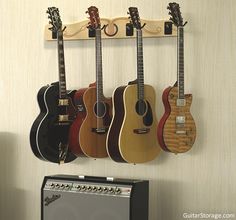 guitars are hanging on the wall next to an amp