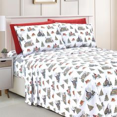 a bed with christmas themed sheets and pillows