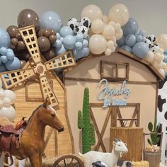 a display of farm animals and balloons in front of a barn