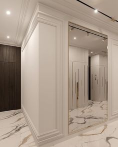 an empty bathroom with marble flooring and white walls, along with large mirrors on the wall