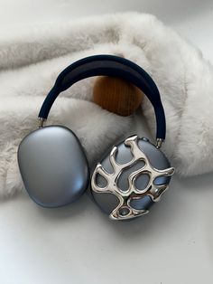 a pair of headphones sitting on top of a white blanket next to a wooden object