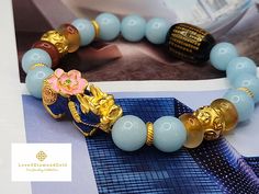 Gift yourself or your loveonce this beautiful bracelet. Crafted with 24 Karat Real Gold, Agate, and Blue Angelite. Pixiu changes color based on Pixius surrounding temperature.   Metal: 24K Gold (Au999) Colour: Yellow Gold Gold Weight: Approximately 4.43grams Citrine Size: Approximately 10mm Metal is Made of Real 24K Gold. Not Gold Filled. Not Gold Plated. Not Gold Vermeil. 🧧Pixiu is a powerful Feng Shui symbol of wealth. It is believed that wearing the symbol of Pixiu brings money and good fortune to its wearer. This mythical creature is also thought to protect people from losing wealth. It also provides you not only physical protection, but also spiritual protection. 🧧Money Ball is a symbol for good fortune, happiness, and success. It is also used as Feng Shui protection in warding off Luxury Bracelets For Festivals As Gifts, Luxury Bracelets For Festivals Gift, Gold Beaded Good Luck Bracelets, Traditional Gold Bracelets As Gifts, Gold Bracelets With Round Beads For Good Luck, Gold Spiritual Bracelets As Gifts, Traditional Yellow Gold Beaded Bracelets As Gift, Traditional Gold Bracelet, Feng Shui Bracelet