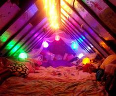 an image of a bedroom with colorful lights in the ceiling and on the bed sheets