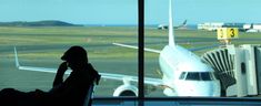 a person sitting in front of an airport window