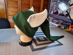 a green and white hat sitting on top of a table