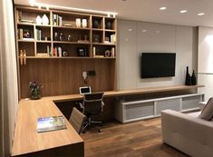 a living room filled with furniture and a flat screen tv mounted on a wall next to a window