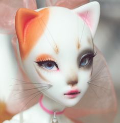 a close up of a cat doll with orange and white markings on it's face