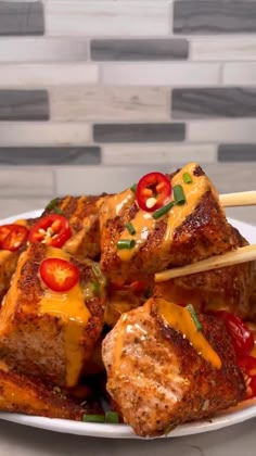 tofu on skewers with tomatoes and peppers are served on a white plate