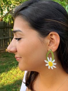 a close up of a person wearing some kind of earring with a flower on it