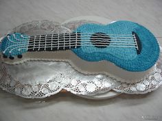 a cake shaped like a guitar on top of a doily