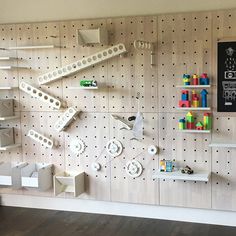 a room with pegboard, shelves and a television mounted to the side of it