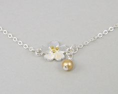 Delicate flower bracelet in silver and gold. Sterling silver bracelet chain and dimensional flower with gold plated stamen. Small Swarovski crystal pearl accent in your choice of colors. Bracelet is small - 6 3/4 inches long with a 1 inch extender chain. Add to your jewelry wardrobe or give her a special gift. Pearl color in photo is gold. 4mm crystal pearl colors: 1 - Gold 2 - Platinum 3 - Cream 4 - White 5 - Yellow 6 - Rose Gold 7 - Rose Peach 8 - Pink 9 - Pastel Blue 10 - Light Blue 11 - Past Gold Flower Bracelet, Silver Flower Bracelet, Dangle Bracelet, Jewelry Wardrobe, Rose Peach, Bracelet Dainty, Bracelet Chain, Gift For Girls, Gold Flower