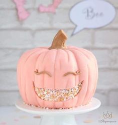 a pink pumpkin decorated with sprinkles and a smile