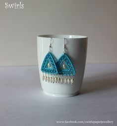 a cup with a pair of earrings on it