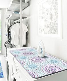 an ironing board on top of a washer and dryer in a room