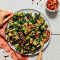 a plate with broccoli and other food on it next to a bowl of chili