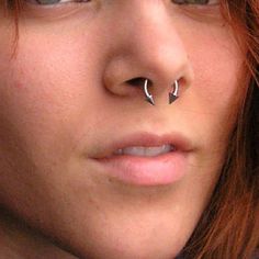 a close up of a person with a nose ring and piercing on it's nose